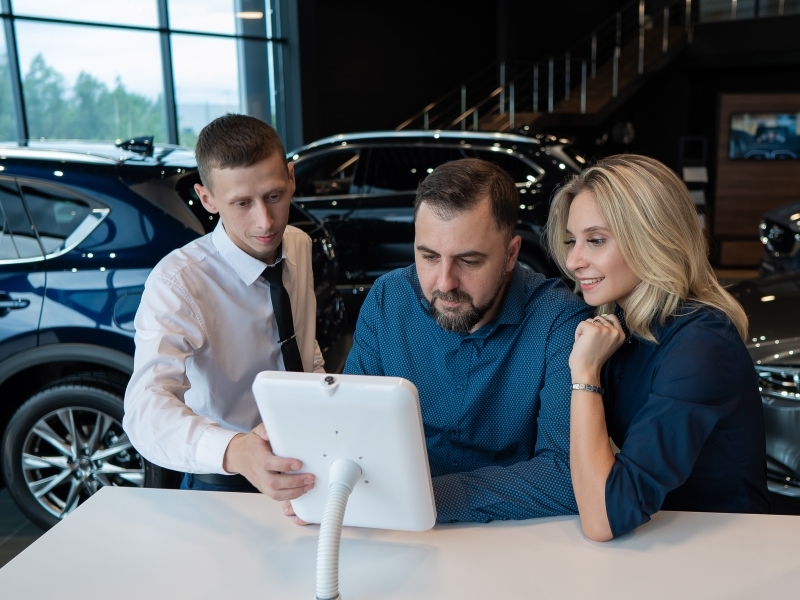 Couple and salesman work thru WebBuy's digital retail process in the showroom